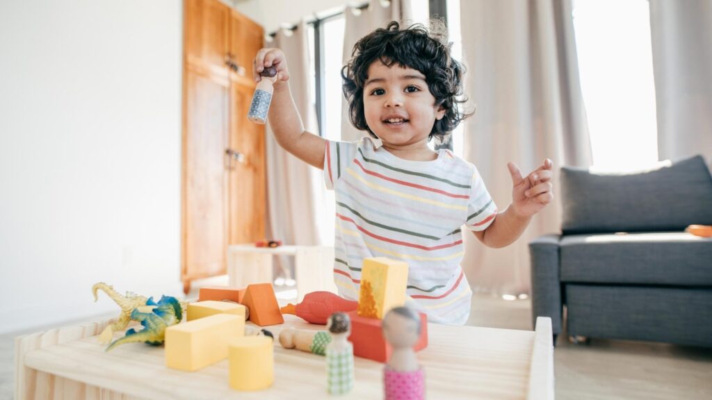 Young boy engaging in Solitary Play with wooden blocks and dinosaurs