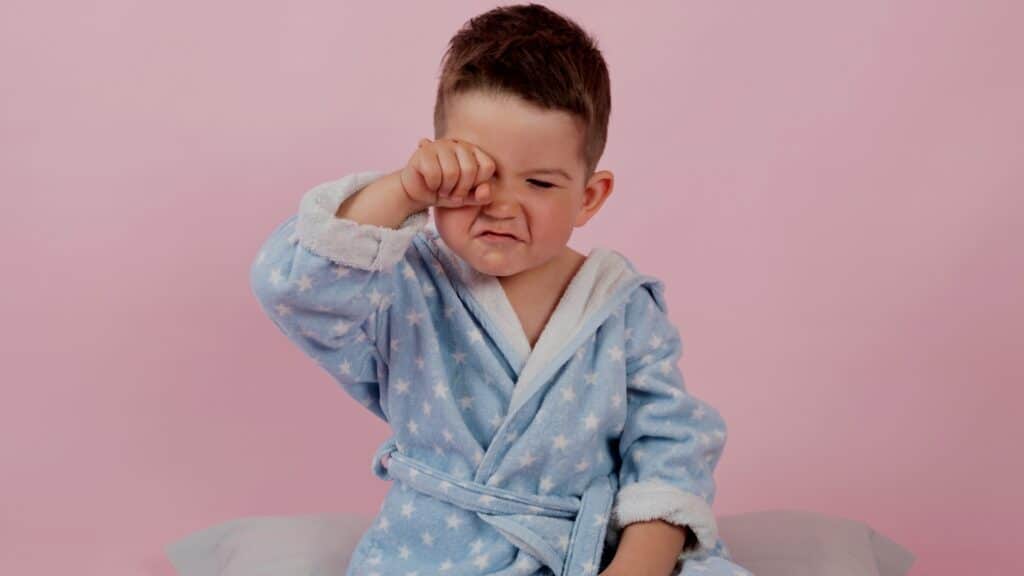 Toddler Stalling At Bedtime - Grumpy toddler wiping his eyes